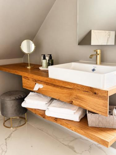 a bathroom with a sink and a shelf with towels at Büdel's Spessart Lounge in Lohr am Main