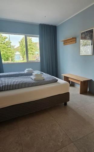 a bedroom with a large bed and a table at Eldá apartments in Myvatn