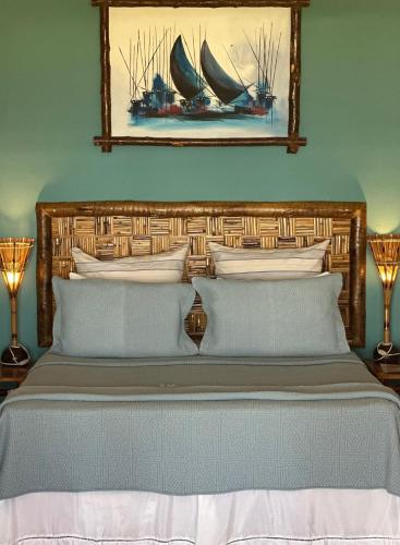 a bedroom with a large bed with a picture on the wall at Hotel Rede Beach in Trairi