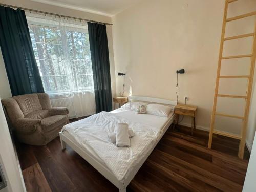 a bedroom with a bed and a chair and a window at Ocypello in Ocypel