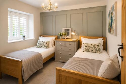a bedroom with two beds and a window at River Song, Aysgarth Falls in Leyburn