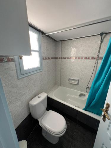 a bathroom with a toilet and a bath tub at Ageon Amorgos in Amorgos