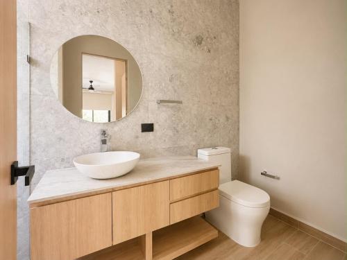 a bathroom with a sink and a mirror and a toilet at Villa horizonte in Playa del Carmen