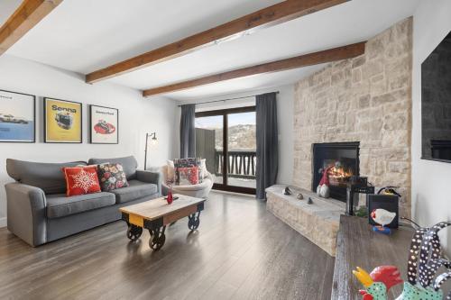 a living room with a couch and a fireplace at Luxury Condominium with Rustic Minimalist Style in Mont-Tremblant