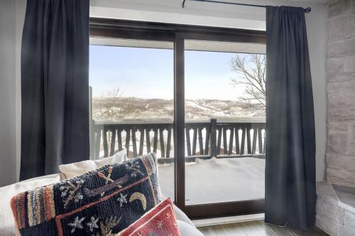 a room with a window with a view of a balcony at Luxury Condominium with Rustic Minimalist Style in Mont-Tremblant
