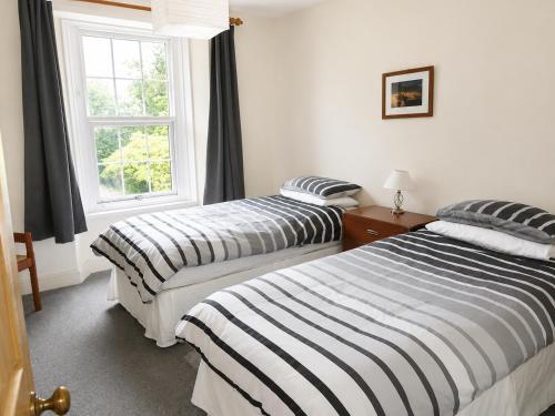 two beds in a room with a window at lake District cottage in Bootle