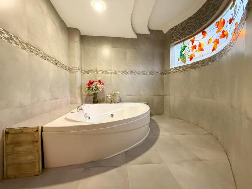 ein Badezimmer mit einer großen Badewanne und einem Fenster in der Unterkunft Hotel Casa Ruth Cuenca in Cuenca
