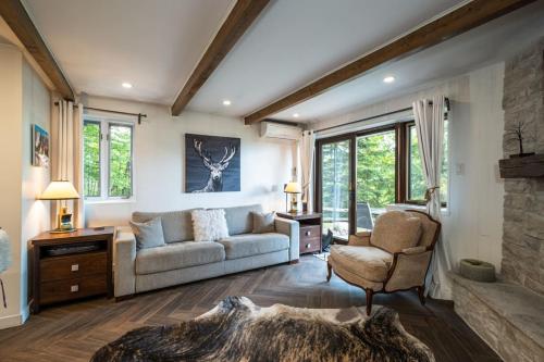 a living room with a couch and a chair at Simple & Luxe Condo With View in Mont-Tremblant