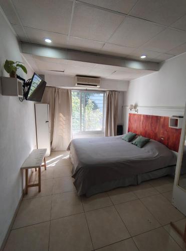 a bedroom with a bed and a television in it at Apart Zeta in Belén de Escobar
