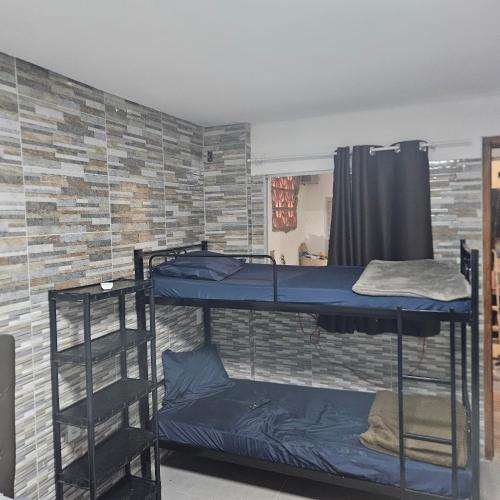 two bunk beds in a room with a brick wall at Hotel Rei in São Bernardo do Campo