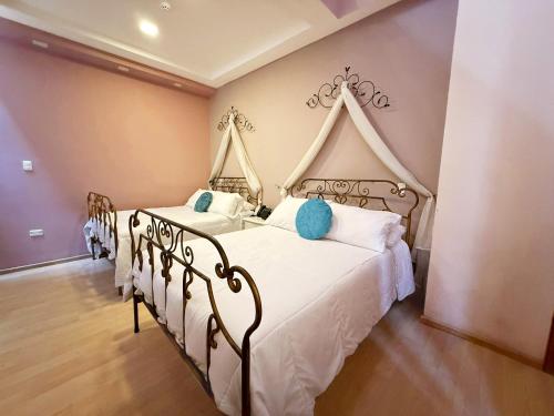 ein Schlafzimmer mit zwei Betten mit weißen Laken und blauen Kissen in der Unterkunft Hotel Casa Ruth Cuenca in Cuenca