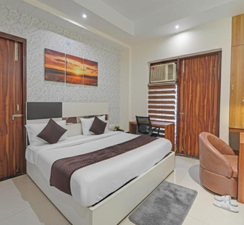 a bedroom with a large bed and a chair at Hotel Church House - Rohini I Near Metro I Spacious Rooms I Friendly Staff I Most Preferred Hotel In Rohini in Delhi