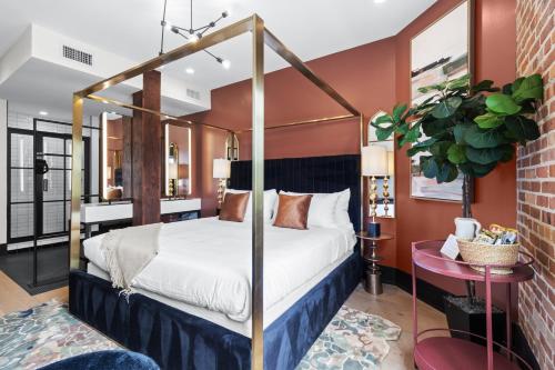 a bedroom with a four poster canopy bed at Eleven48 Hotel in New Orleans