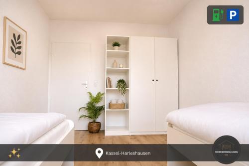a white bedroom with two beds and a white cabinet at Ferienwohnung Kassel mit Ladesäule in Kassel