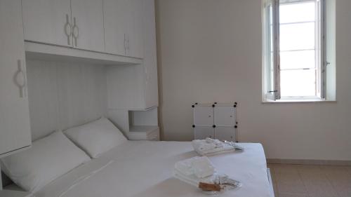 a white room with a white bed and two windows at Il Rigoletto Casa Vacanze in Lamezia Terme