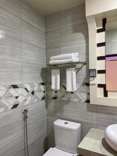a bathroom with a white toilet and a sink at Sunview Residence in Kaashidhoo