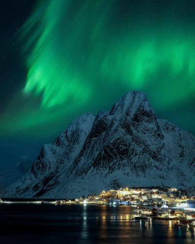 an image of a mountain with the northern lights at Astra Whale - Waterfront Boutique Hostel in Lofoten in Kabelvåg