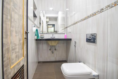a bathroom with a toilet and a sink and a mirror at Yash villa - 2 Bhk ll Private pool ll Wifi ll Tv ll in Lonavala