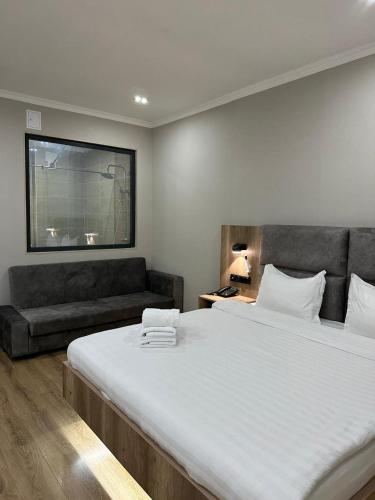a bedroom with a large bed and a couch at Palace&Spa Rooms in Shymkent
