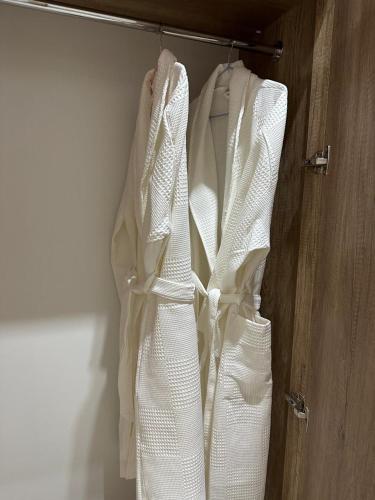 a white wedding dress hanging on a rack at Palace&Spa Rooms in Shymkent