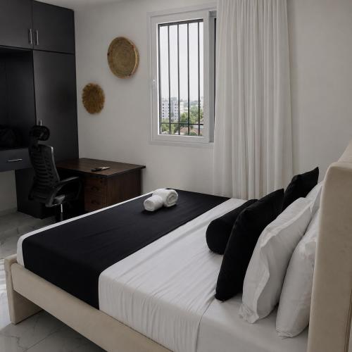 a bedroom with a bed and a desk and a window at Soft stay homes in Mombasa
