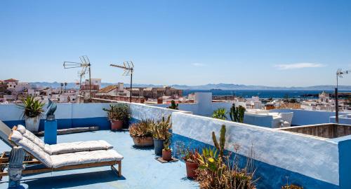 a balcony with chairs and potted plants on a roof at La Estrella de Tarifa in Tarifa