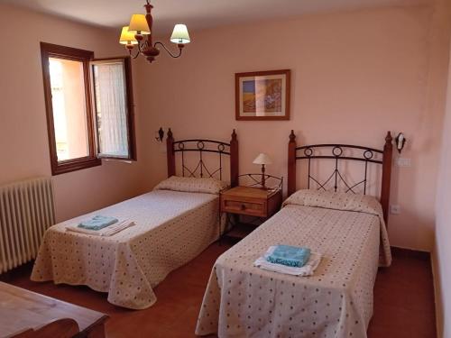 a bedroom with two beds and a window at Casa Flor de Rello in Rello