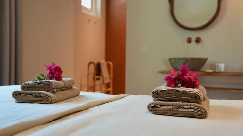 two towels with flowers on top of a bed at Coconuts Tropical Boutique Hotel Curaçao in Willemstad