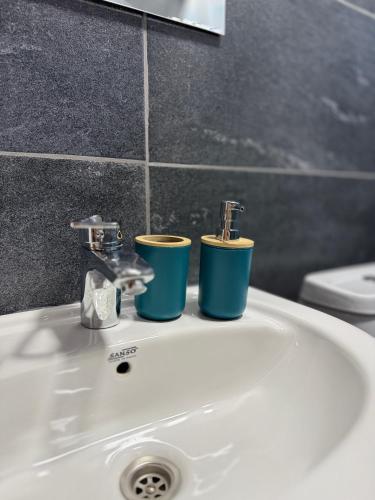 a bathroom sink with two cups on top of it at Sky Tusheti in Omalo