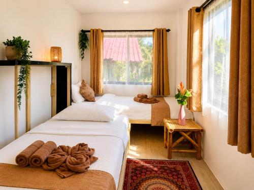 two beds in a room with a window at The Verandas in Hinkong