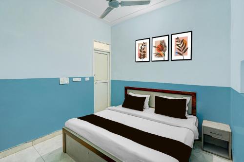 a bedroom with a large bed with blue walls at Hotel O Urban Rooms in Neemrana
