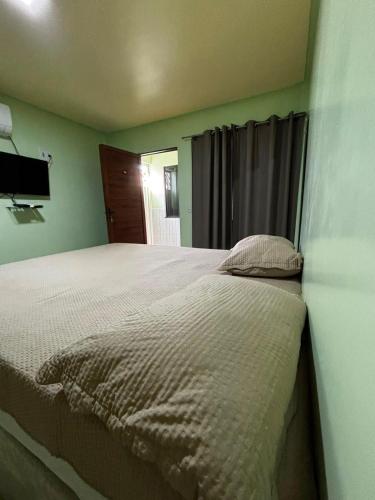 a bedroom with a large bed in a room at Pousada Amorim in Frecheirinha