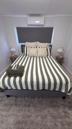 a large bed with a black and white striped comforter at Family Friendly One Bedroom Studio in Brisbane