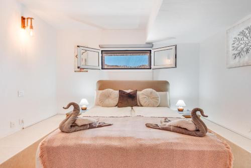 two snakes sitting on a bed in a bedroom at Moser Living Premium Apartments - Puerto Rico in Mogán