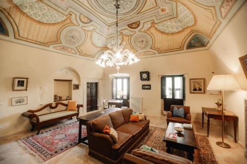 a living room with a couch and a chandelier at B&B Palazzo Agrippa in Bominaco