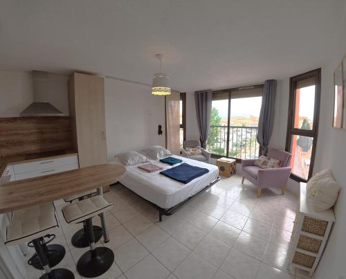 a bedroom with a bed and a table in a room at Charmant studio Toi et Moi à 30 m de la plage et de Valras centre avec linge de lit et ménage inclus in Valras-Plage