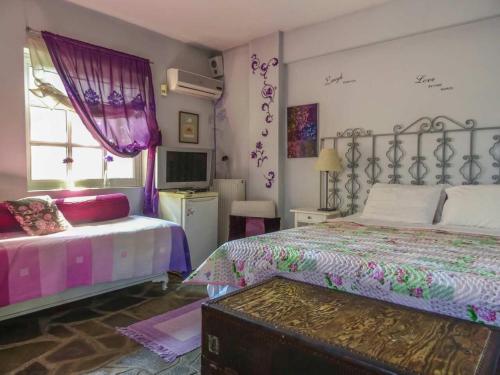 a bedroom with two beds and a tv in it at St. Thomas Bed and Breakfast in Paianía