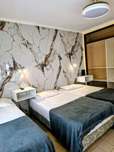 a bedroom with two beds and a marble wall at Kairos in Buenos Aires