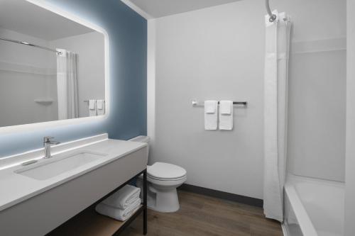 a bathroom with a sink and a toilet and a mirror at StudioRes by Marriott Clearfield Layton in Clearfield