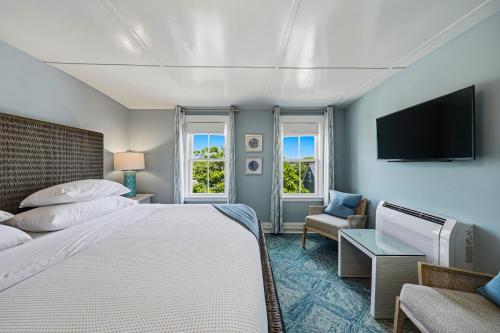 a bedroom with a bed and a tv and a couch at Carlisle House Inn in Nantucket