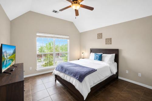 a bedroom with a bed and a ceiling fan at Spacious 4BR Retreat |Pool Table| Firepit & Hottub in Kyle