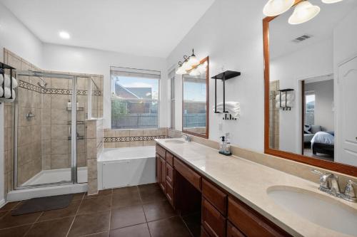 a bathroom with a tub and a sink and a shower at Spacious 4BR Retreat |Pool Table| Firepit & Hottub in Kyle