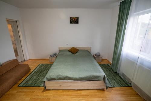 a bedroom with a bed in a room with a window at Klára House - Covasna in Covasna