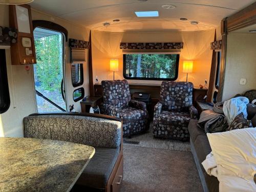 a living room in an rv with chairs and a couch at The Boardwalk in Westfield Beach