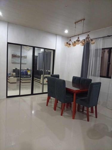 a dining room with a table and some chairs at Next House Passi City in Iprog