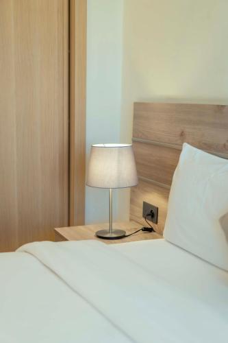 a bed with a lamp on a table next to it at Flamant Rose Appart Hotel in Tangier