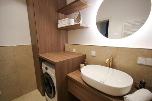 a bathroom with a sink and a washing machine at Appartement Promenadenhirsch in Bad Gastein
