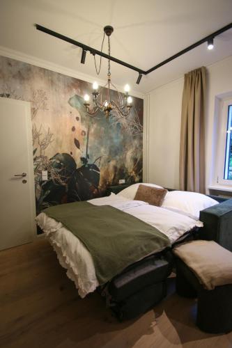 a bedroom with a bed and a chandelier at Appartement Promenadenhirsch in Bad Gastein