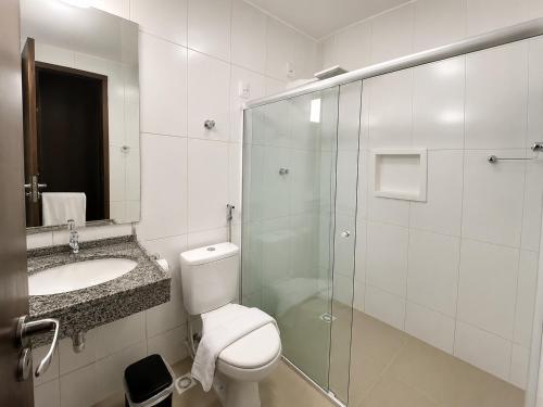 a bathroom with a toilet and a sink and a shower at Caruaru Pallace Hotel in Caruaru