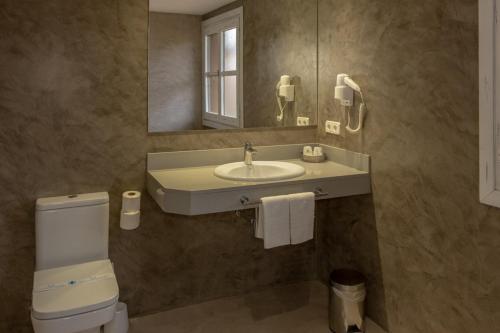a bathroom with a sink and a toilet and a mirror at Hotel Villa de Alquézar in Alquézar